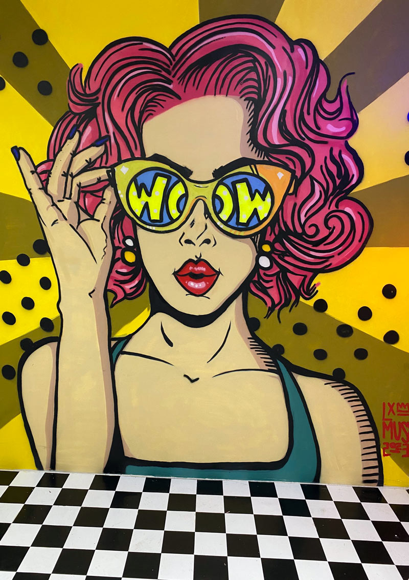 Graffiti von Frau mit Sonnenbrille und Aufschrift "Wow"